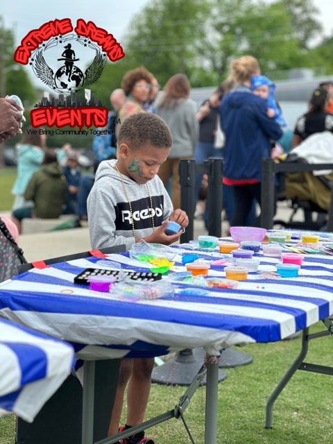 Child painting at a striped outdoor table